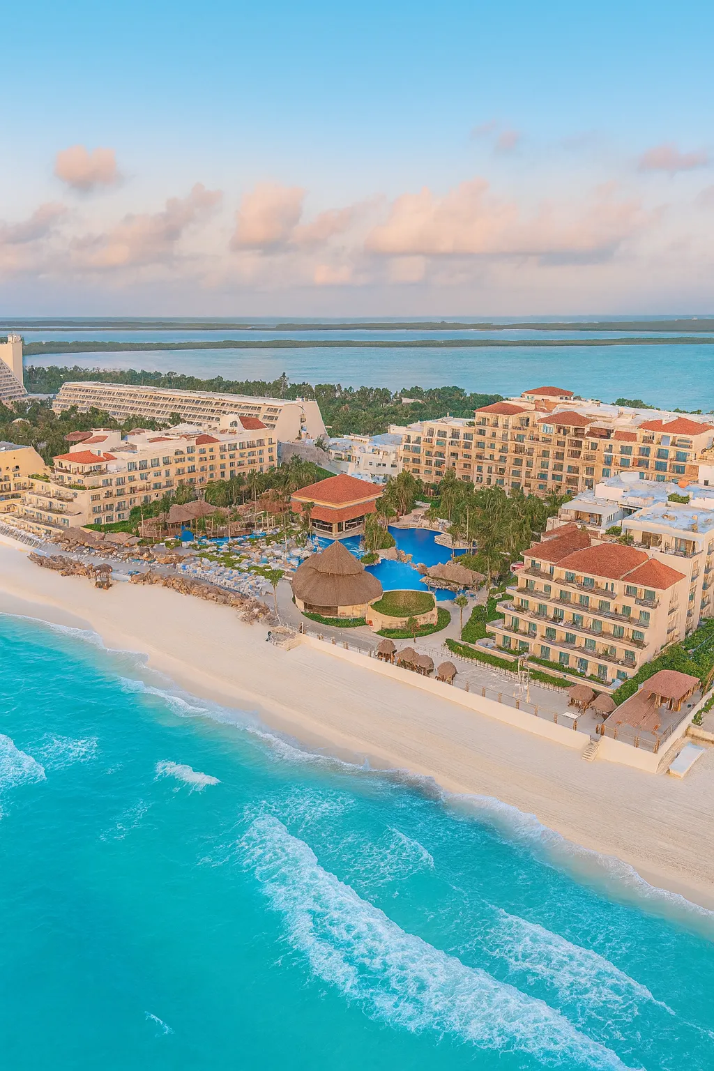 Vista aérea de Cancún con hoteles frente al mar Caribe, playa de arena blanca y aguas turquesa.